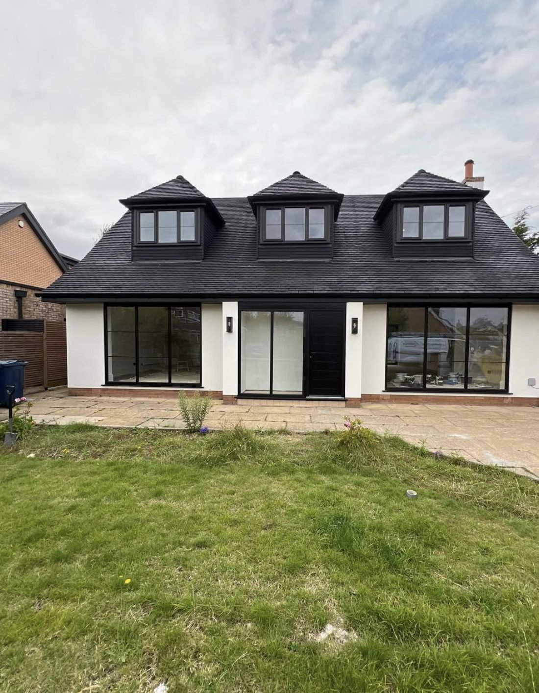 Rear elevation of a chalet bungalow with render run around three sets of openings