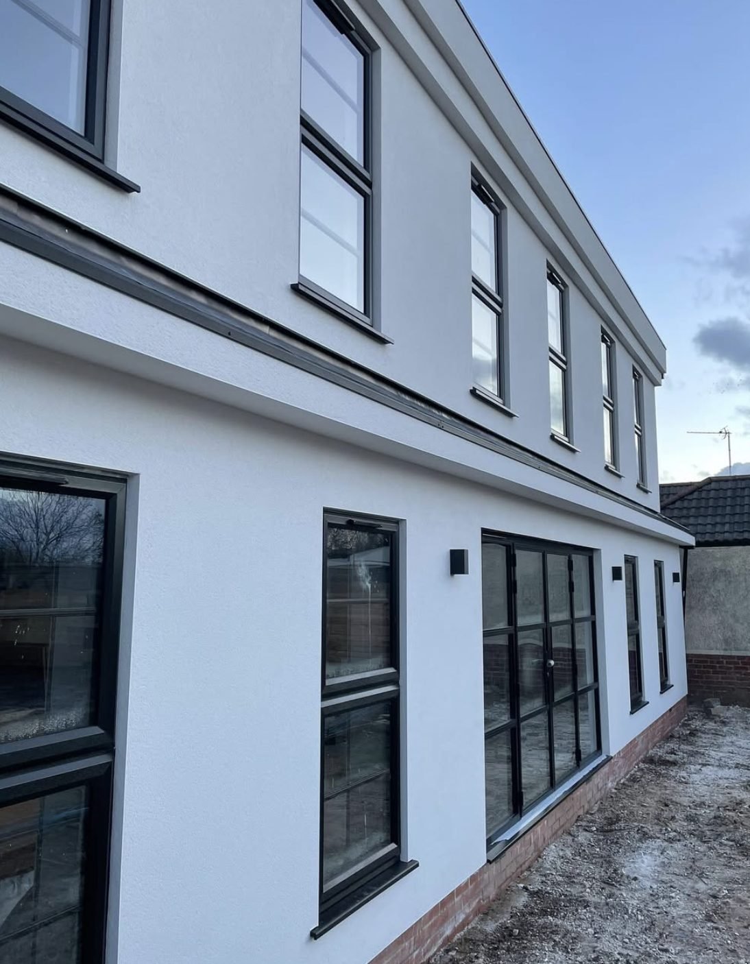 Side elevation of a rendered extension with black framed windows