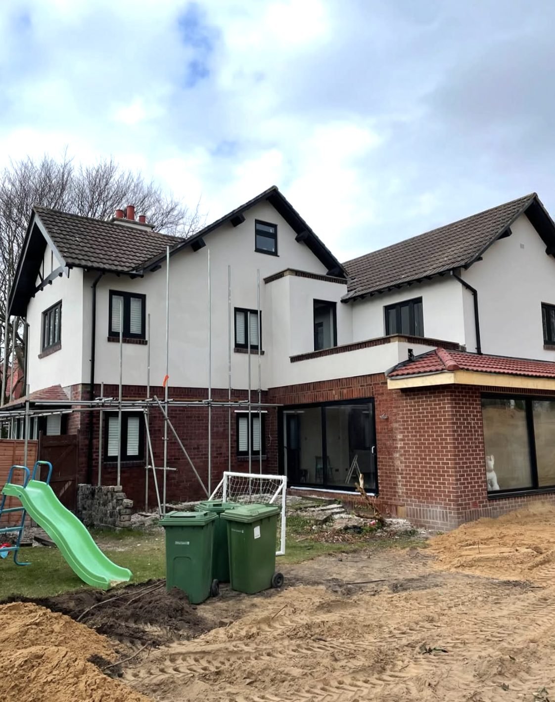 Large rear elevation part rendered with scaffold and brickwork below