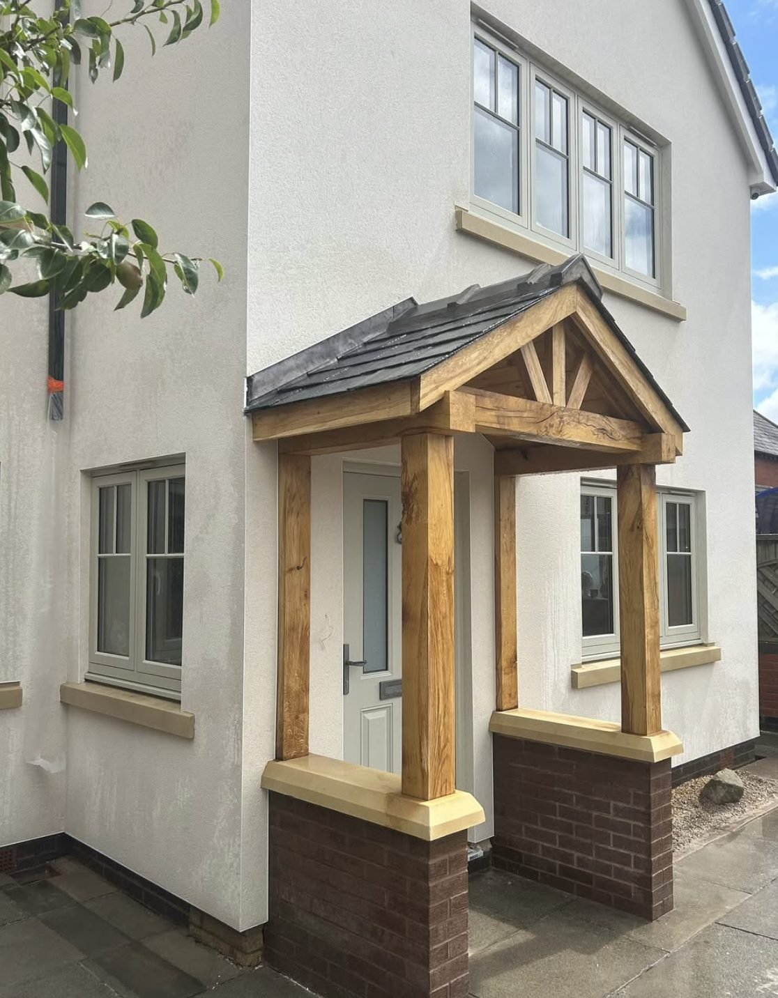 Smooth render elevation worked around an oak framed porch and stone cills