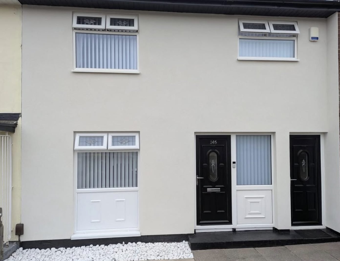 Two terraced houses brought under a single smooth render finish