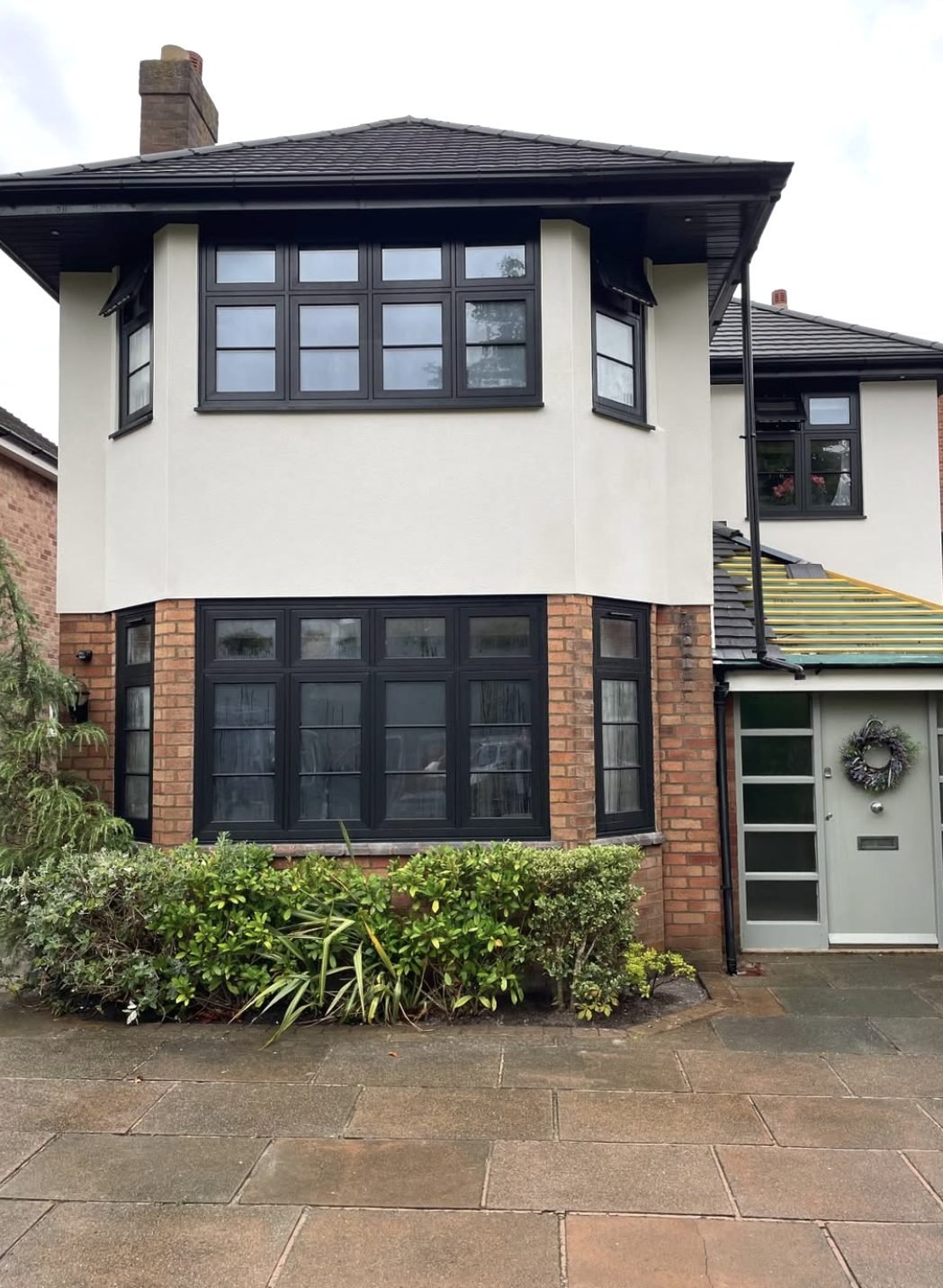 Cream render to the upper elevation above a retained brick bay